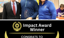 Three people posing together in front of a plaque, celebrating an award for impact.